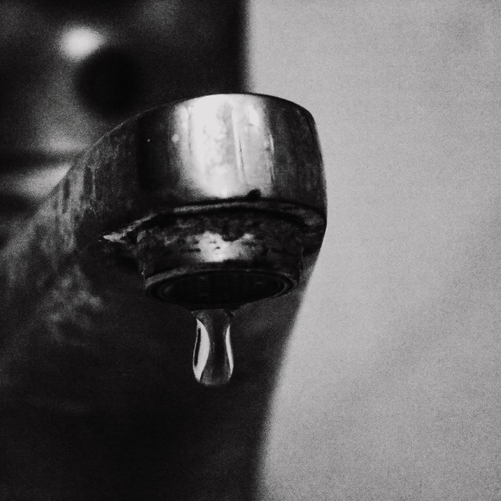 Water dripping from a faucet, the kind of small leak that becomes water damage when left alone